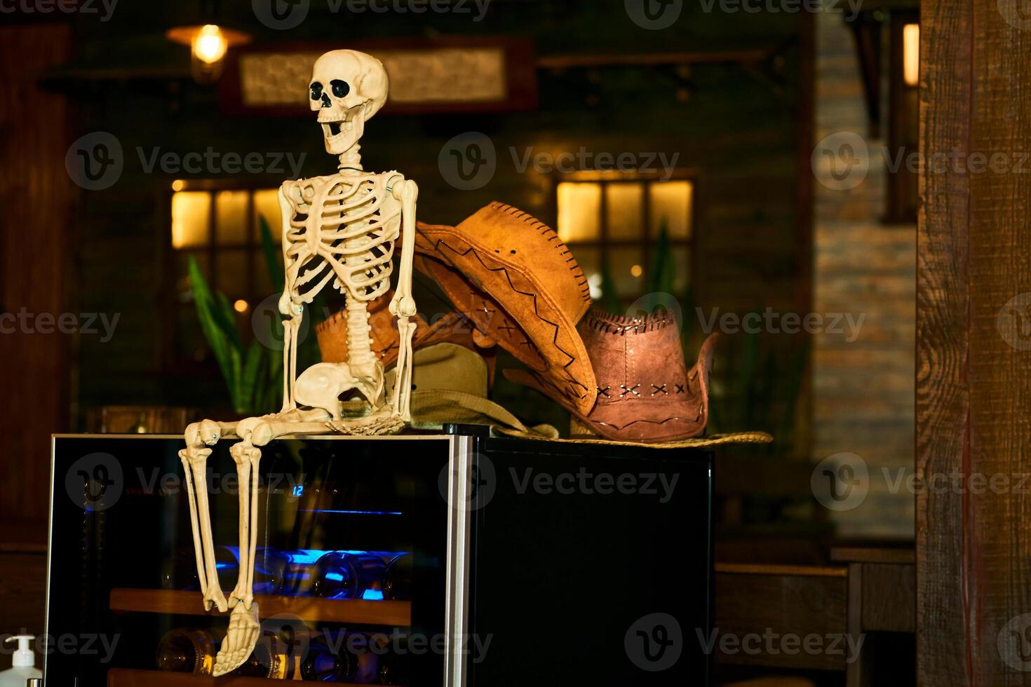 Orange halloween skeleton,cowboy hats in dark pub photo