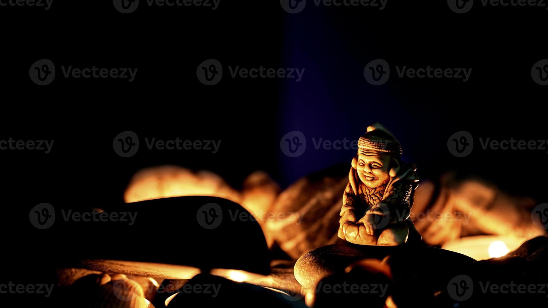Figurine of the holy Buddha, mineral stones,light in night photo