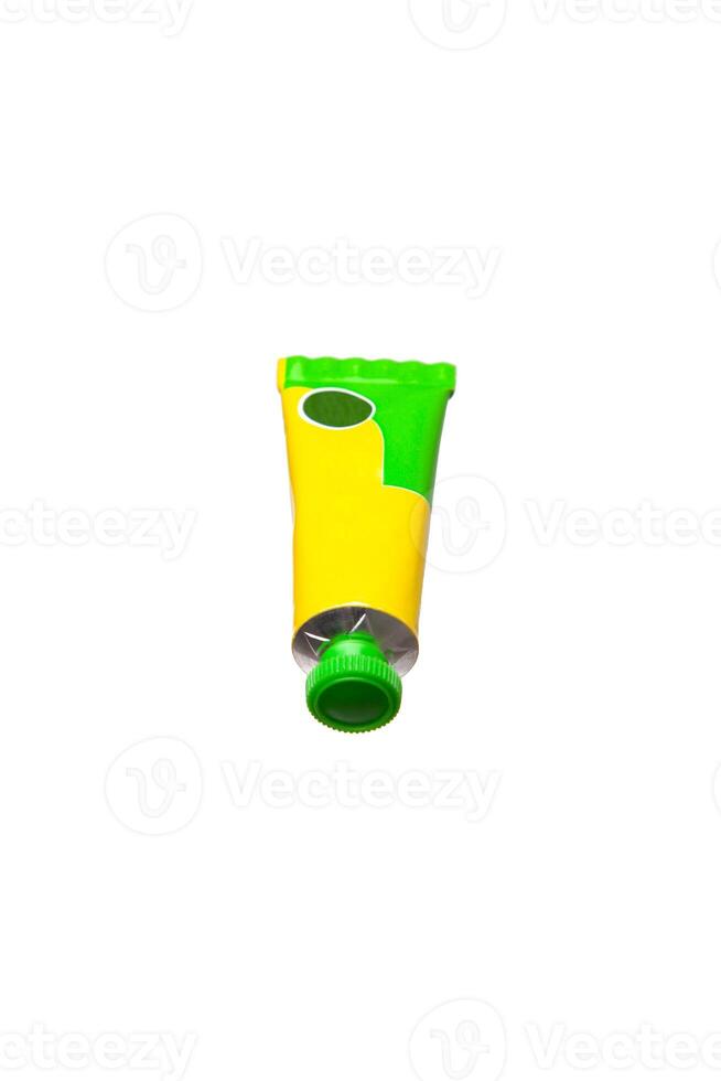 Yellow and green tube with a green cap, isolated on white background, ideal for product packaging mockups. photo