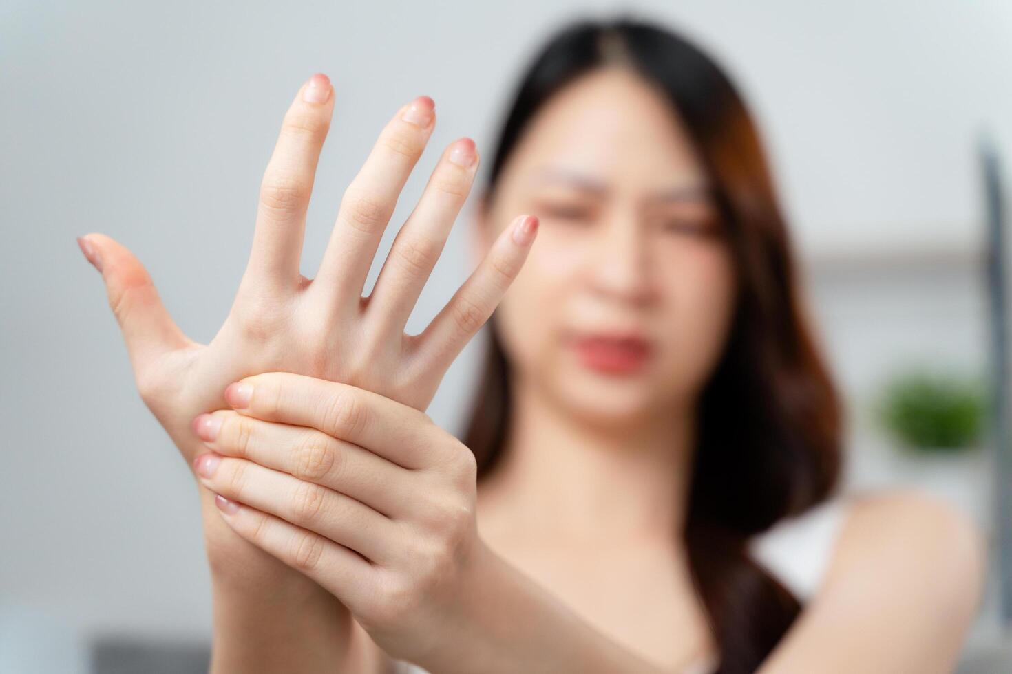 Closeup young woman sitting on sofa holds her wrist. hand injury, feeling pain. Health care. photo