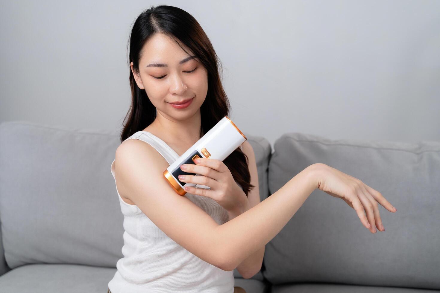 A beautiful woman is epilating and removing hair using an IPL laser hair removal epilator device photo