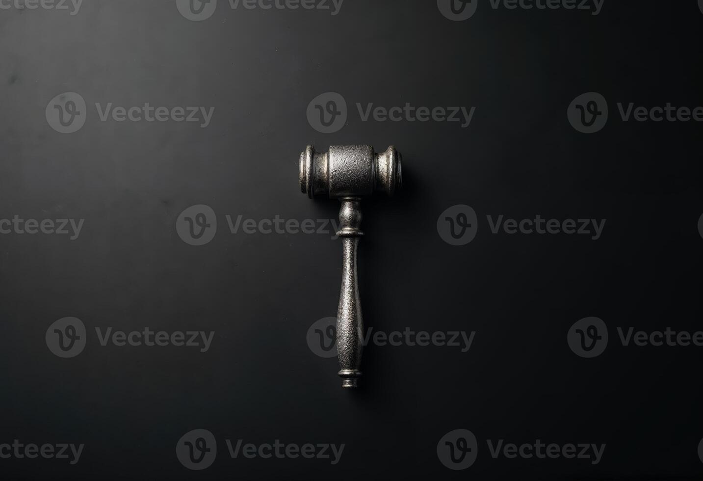 A silver gavel on a black background symbolizing justice and authority. photo