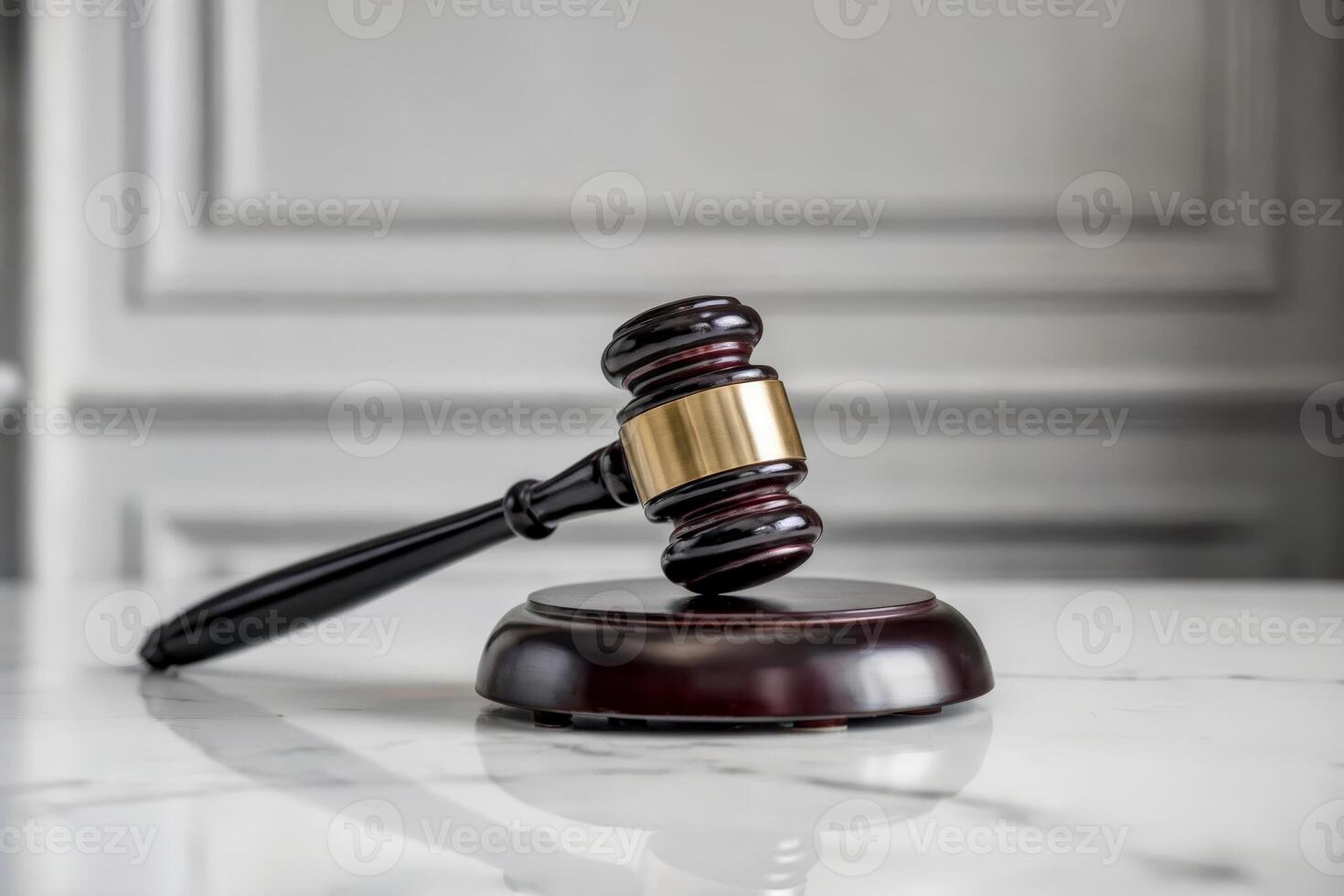 Wooden gavel and sound block on marble table in courtroom setting. photo