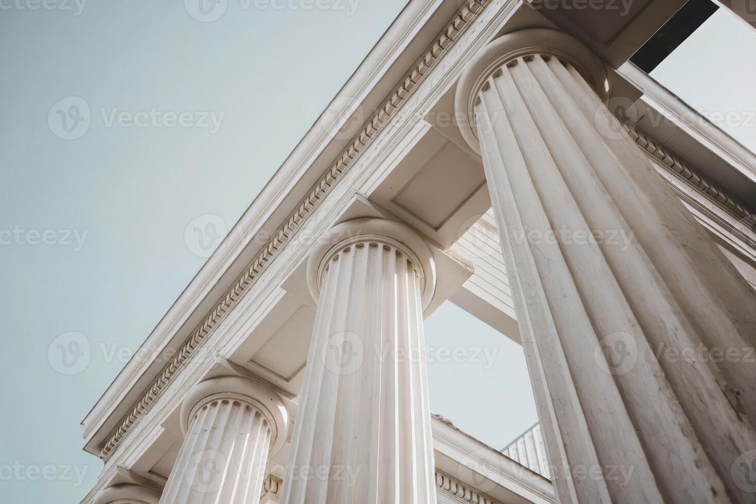 Close-up of majestic white stone columns under a clear blue sky. photo