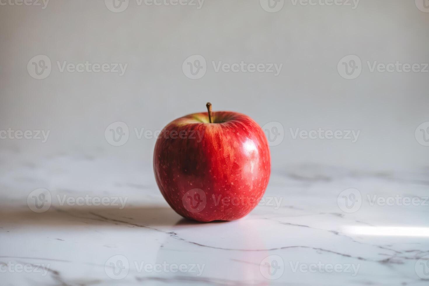 Fresh red apple on a marble surface with natural lighting. photo