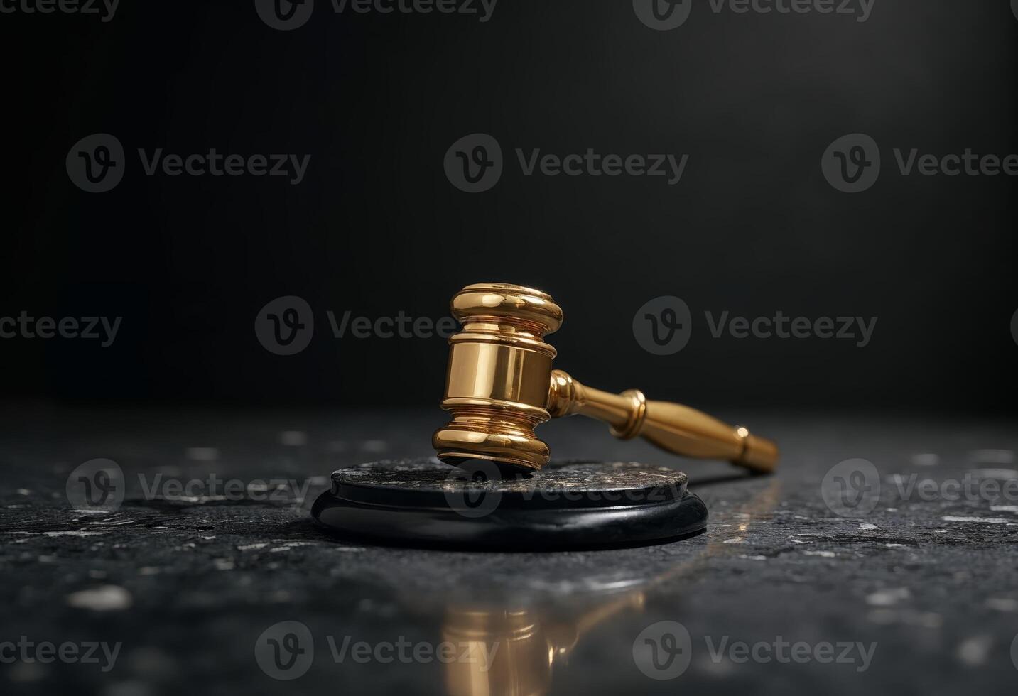 Close-up of a golden gavel on a dark, reflective surface. photo