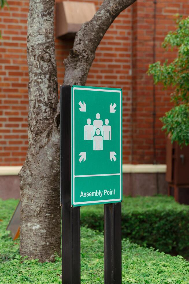 An assembly point sign ensures safety during emergencies, guiding people to a designated gathering area. photo
