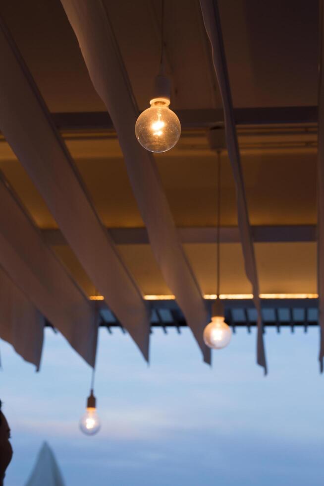 Dusk sets as lights dangle, creating serene ambiance. photo