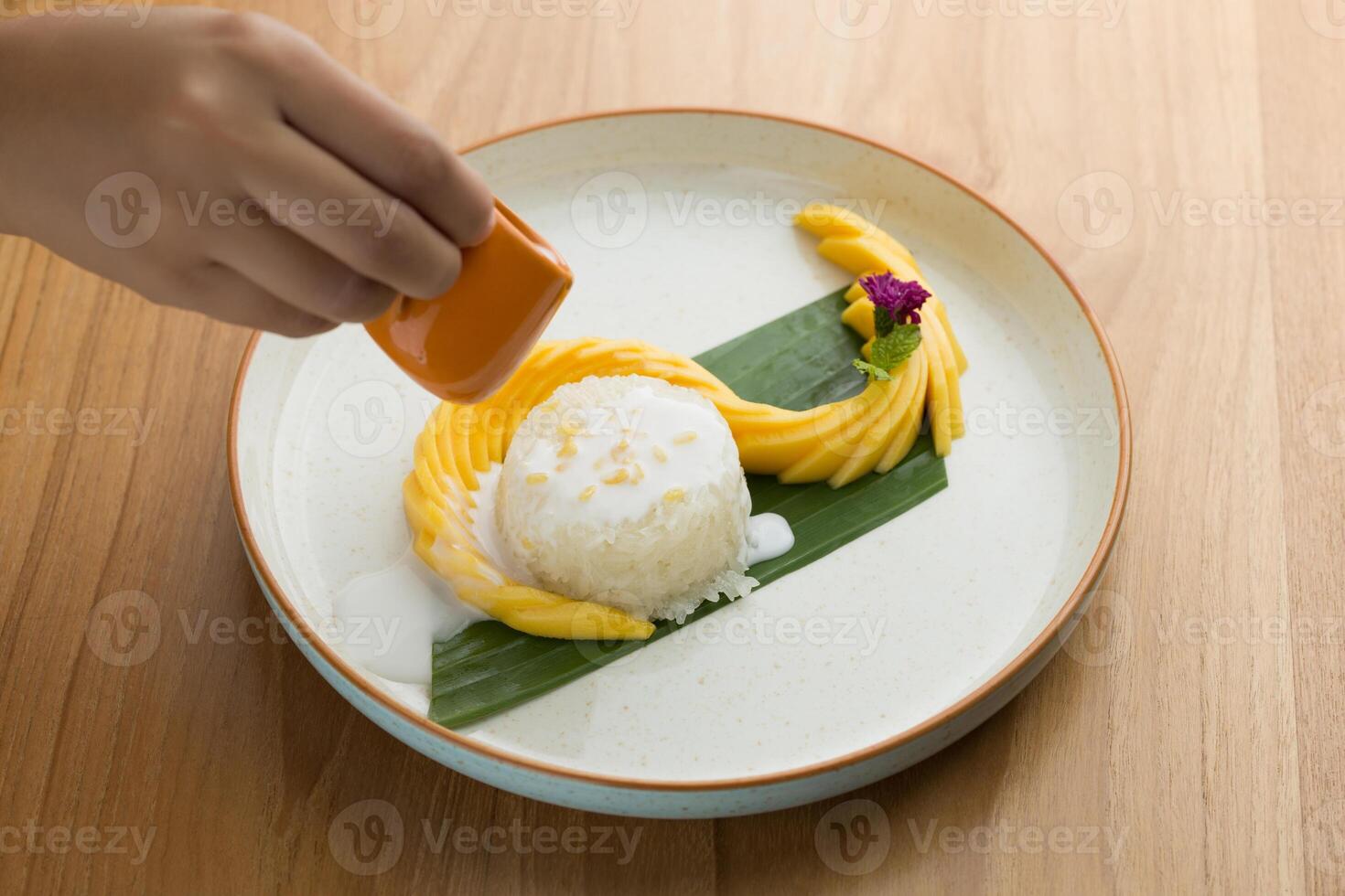 Mango sticky rice, featuring coconut milk as a key ingredient and topped with roasted mung beans for added crunchiness. photo