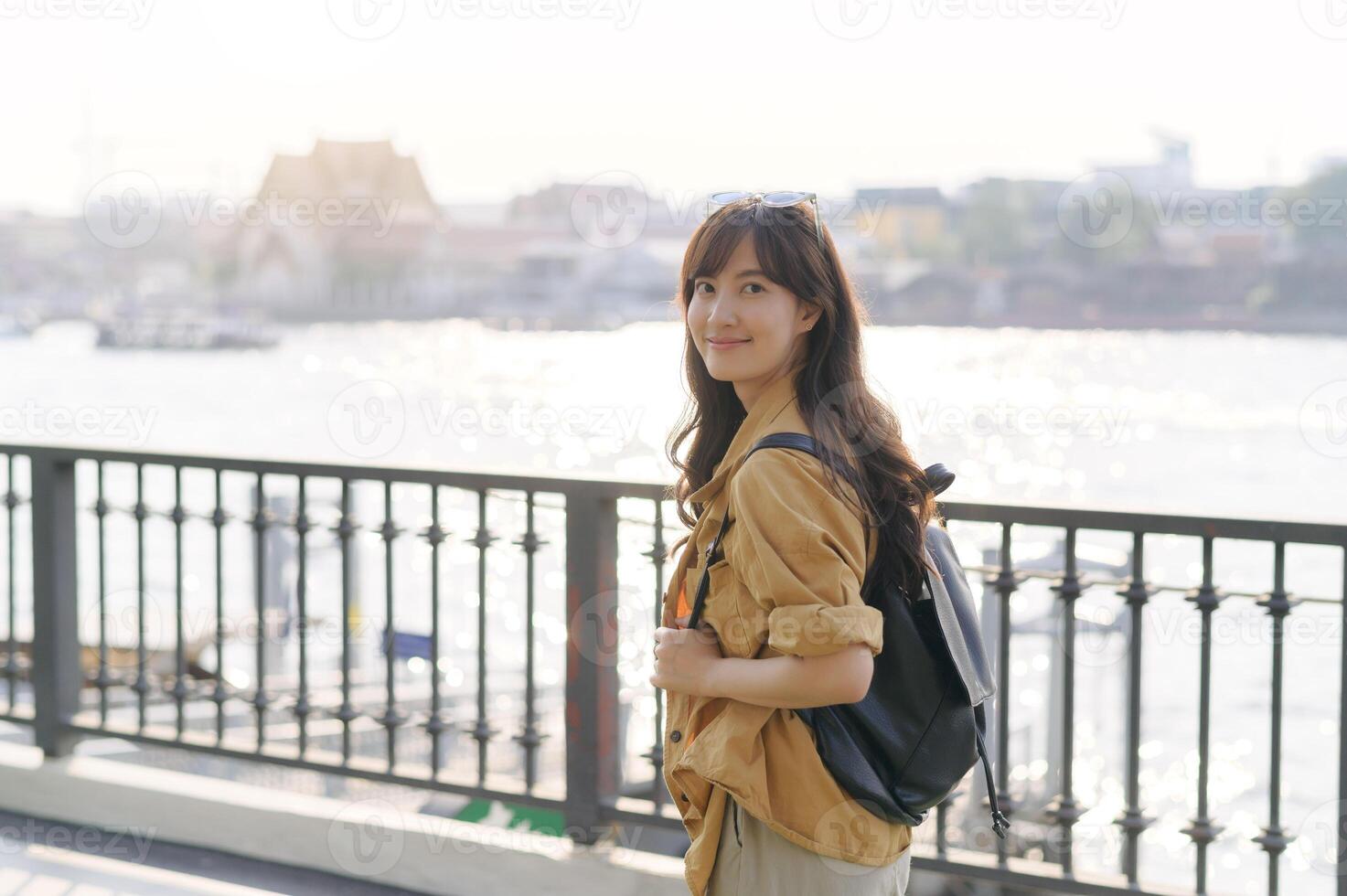a young Asian woman in her 30s embarking on a solo adventure. Backpack on, camera ready, she captures the essence of urban exploration and cultural discovery. photo