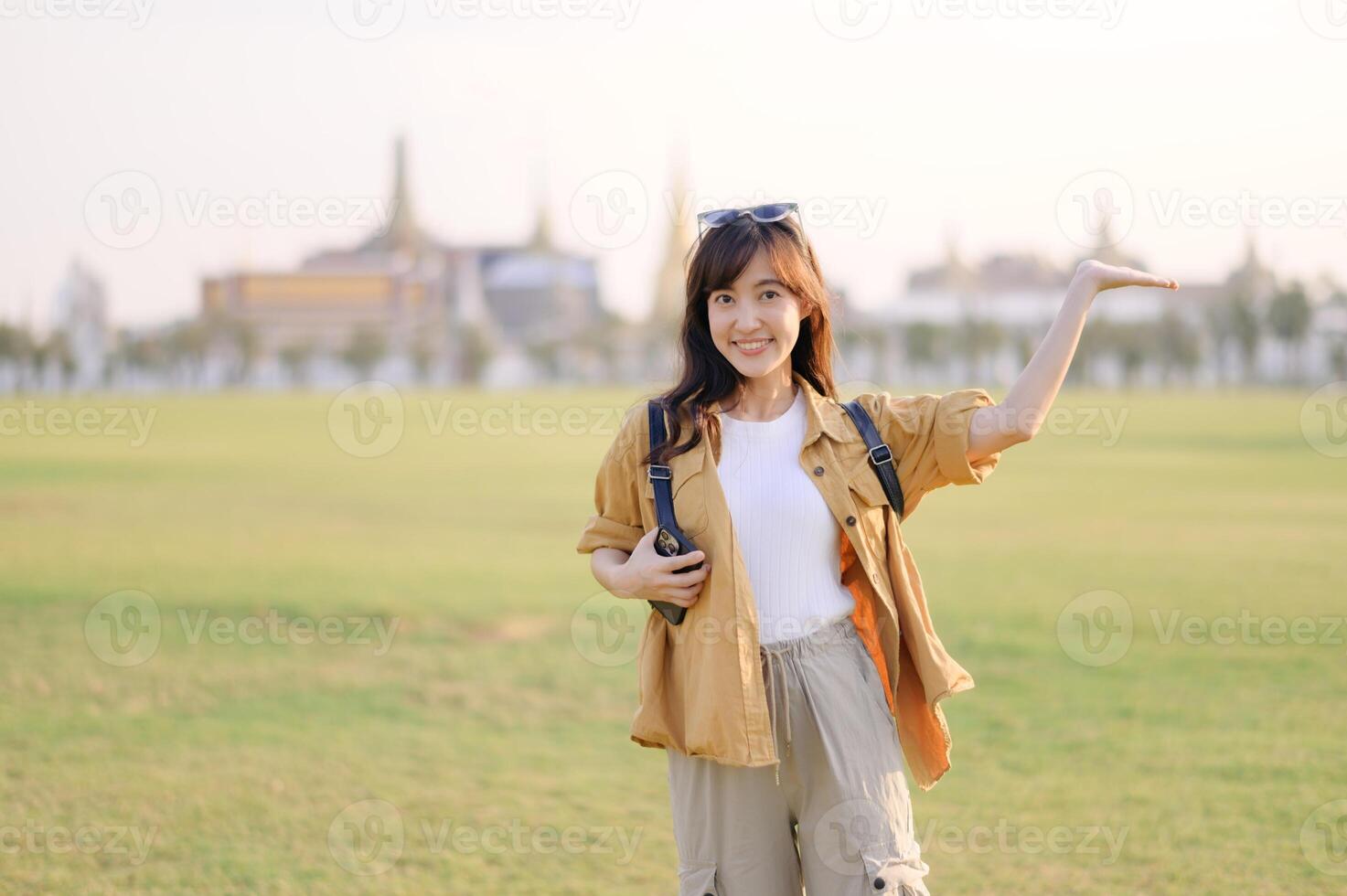 A Traveler Asian woman in her 30s exploring Wat Pra Kaew. From stunning architecture to friendly locals, she cherishes every moment, capturing it all in her heart and camera for years to come. photo