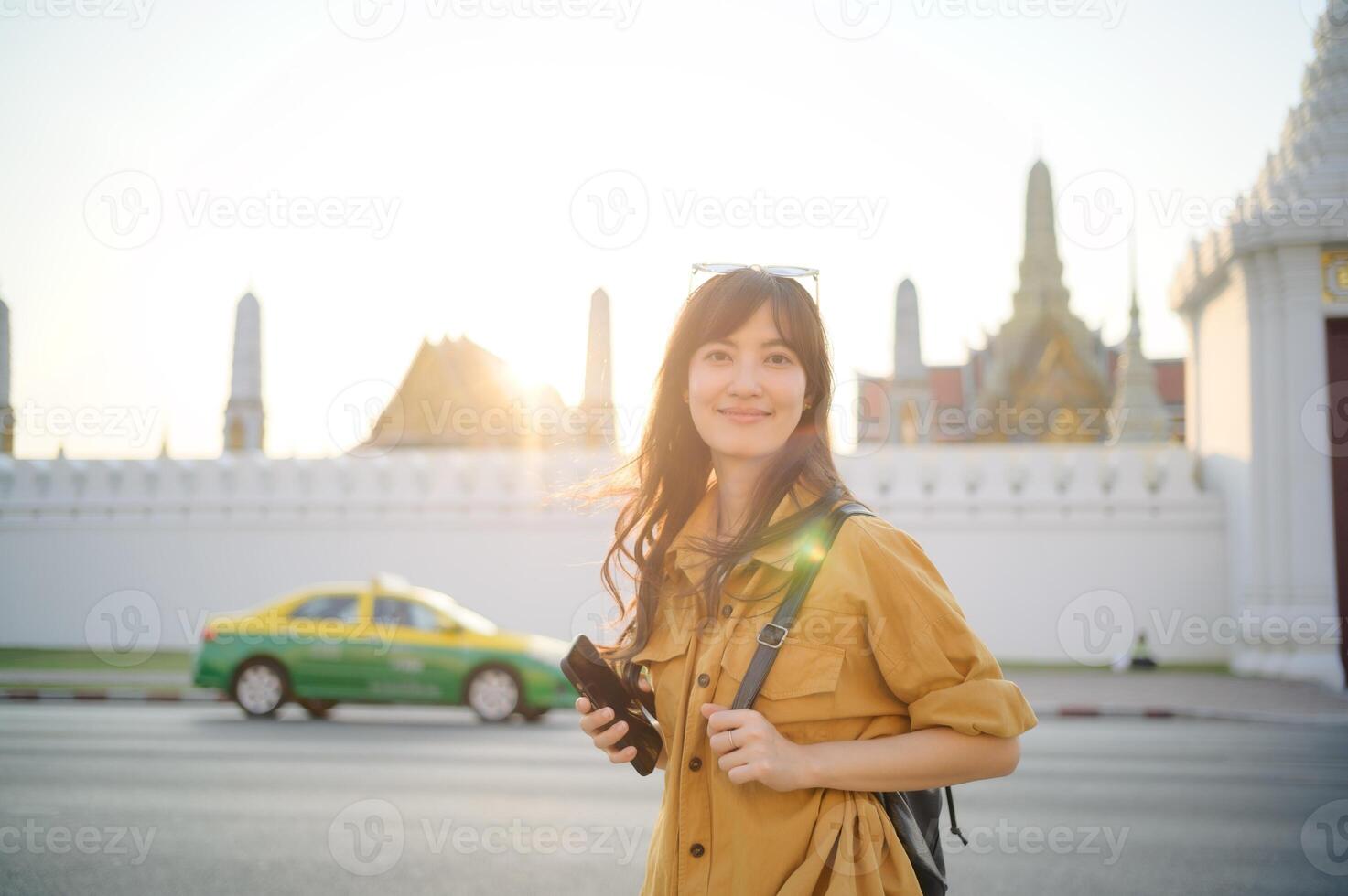 Traveler asian woman in her 30s stands bathed in the golden glow of sunset, embracing the freedom of exploration. on summer holiday weekend vacation trip in Bangkok, Thailand photo