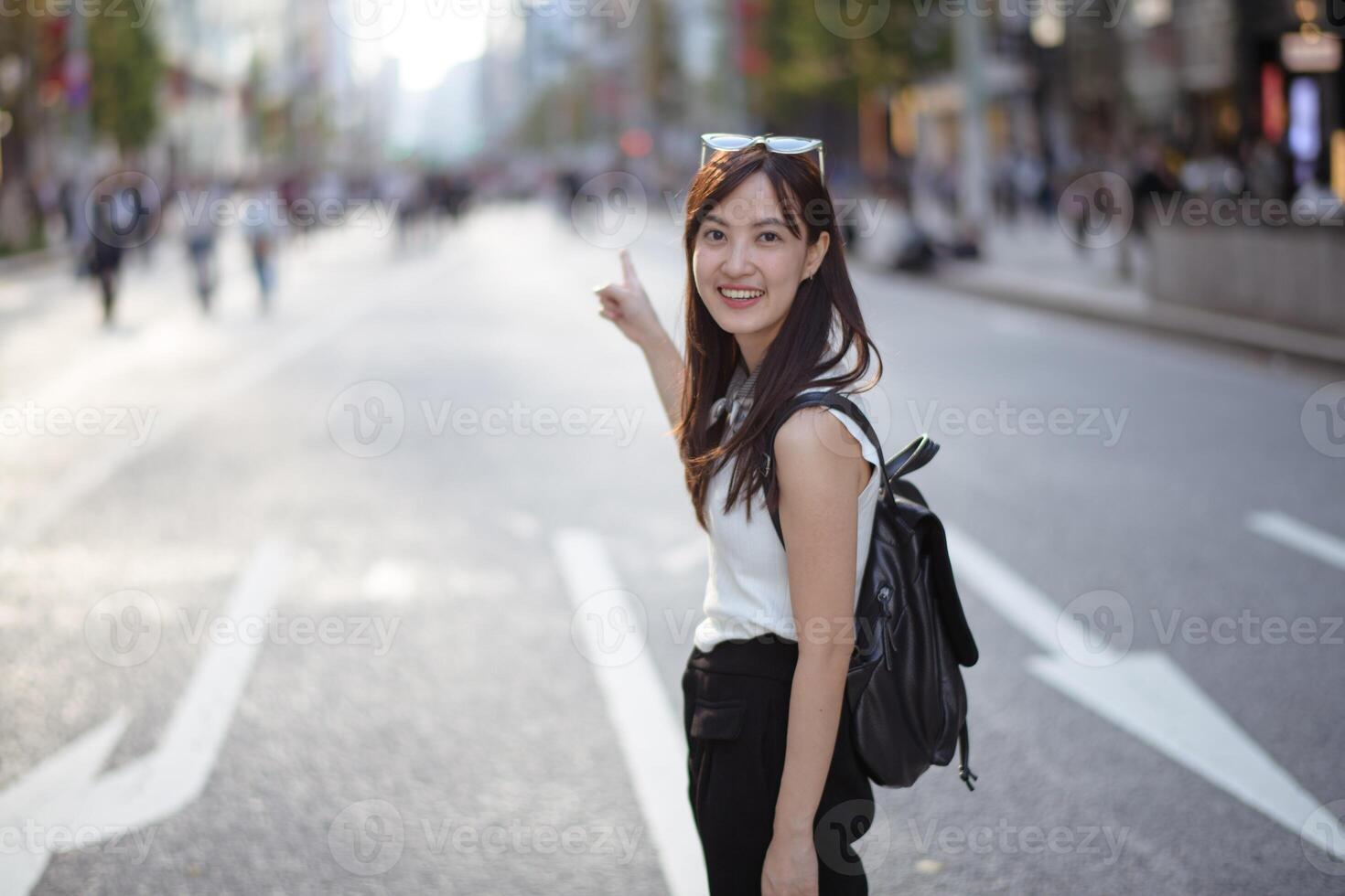 Vibrant and carefree, an Asian woman's urban stroll captures the modern essence of confidence, style, and joyful living. photo