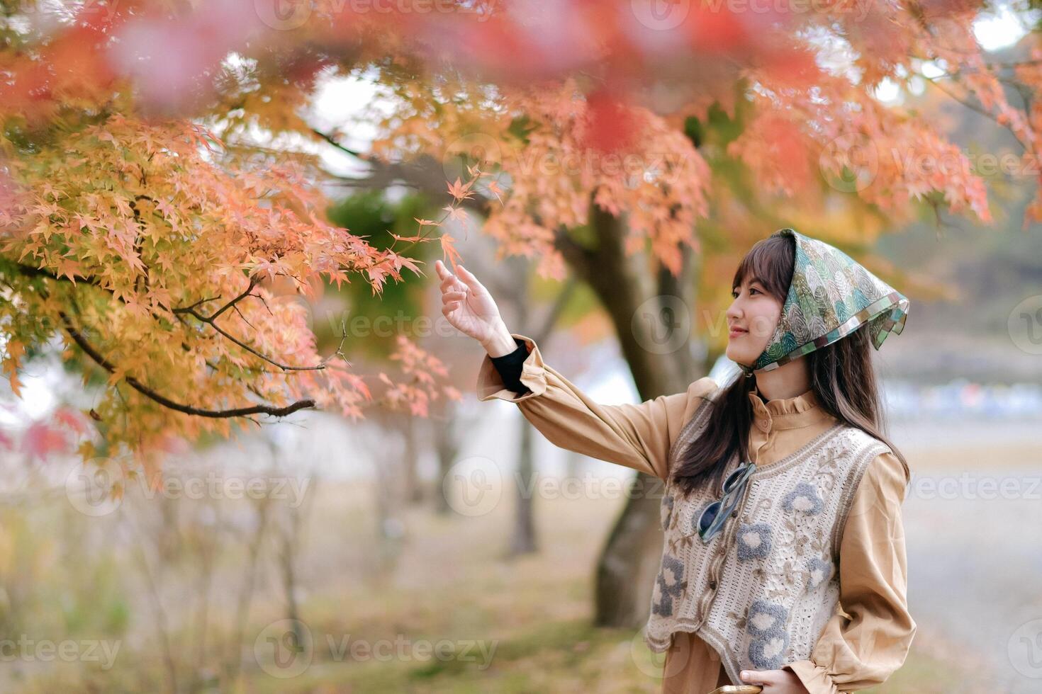Asian woman in Japan's fall beauty, a cheerful holiday portrait in yellow and red foliage. A journey capturing the essence of nature, fashion, and casual elegance. photo