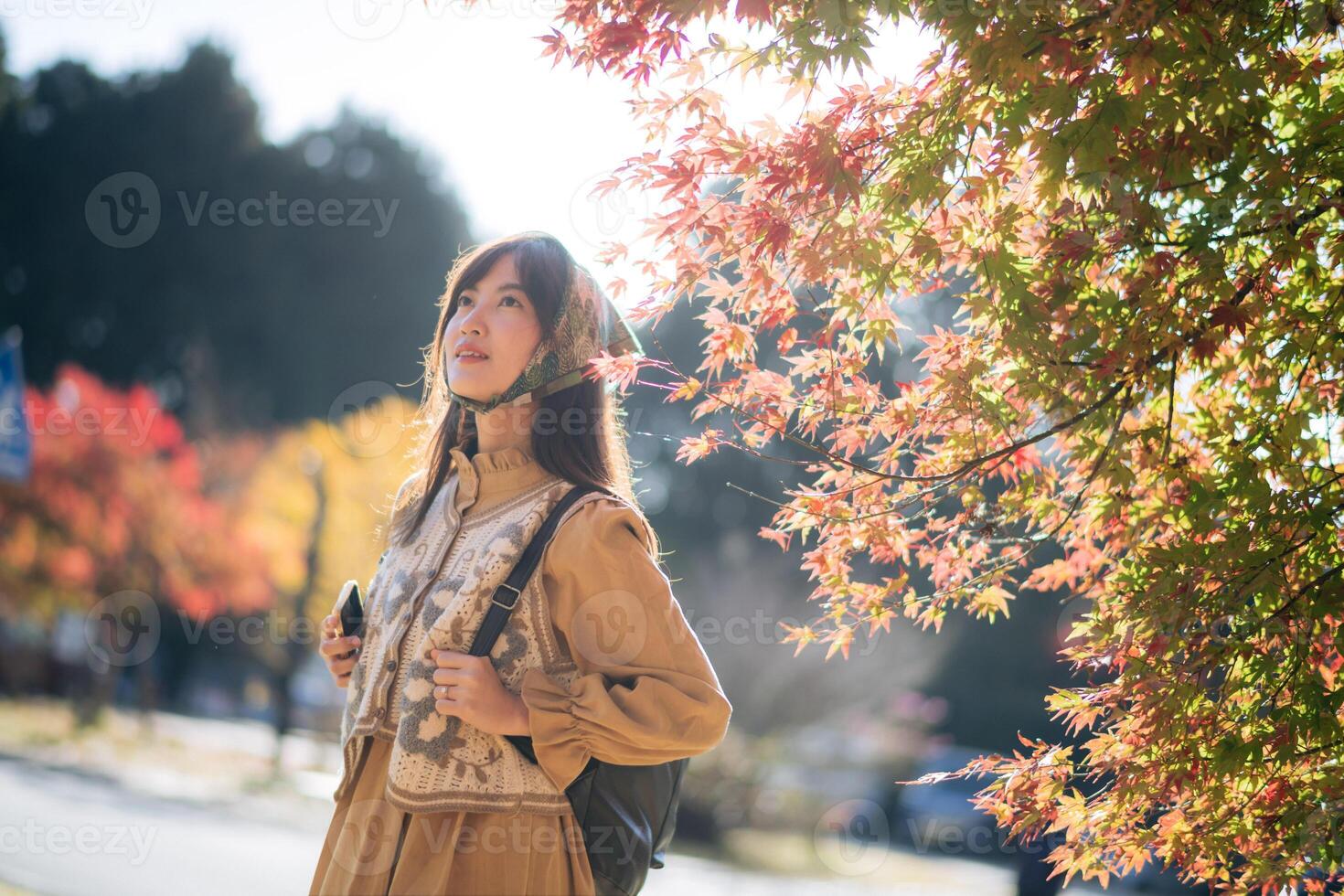 Kyoto's fall joy, Asian woman in a casual dress explores nature's beauty, capturing the vibrant foliage, cheerful smiles, and the essence of Japanese tradition during a holiday. photo