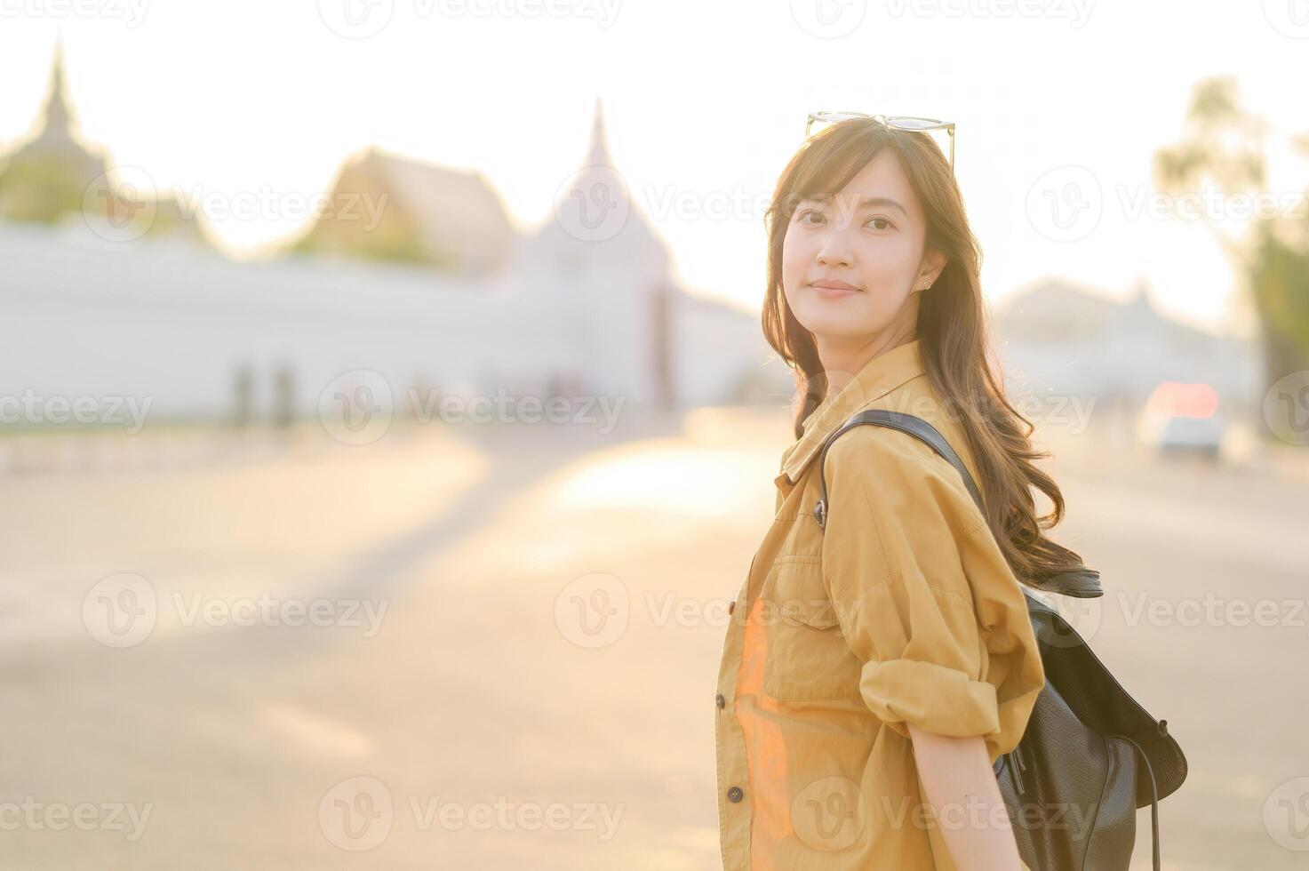 Traveler asian woman in her 30s stands bathed in the golden glow of sunset, embracing the freedom of exploration. on summer holiday weekend vacation trip in Bangkok, Thailand photo