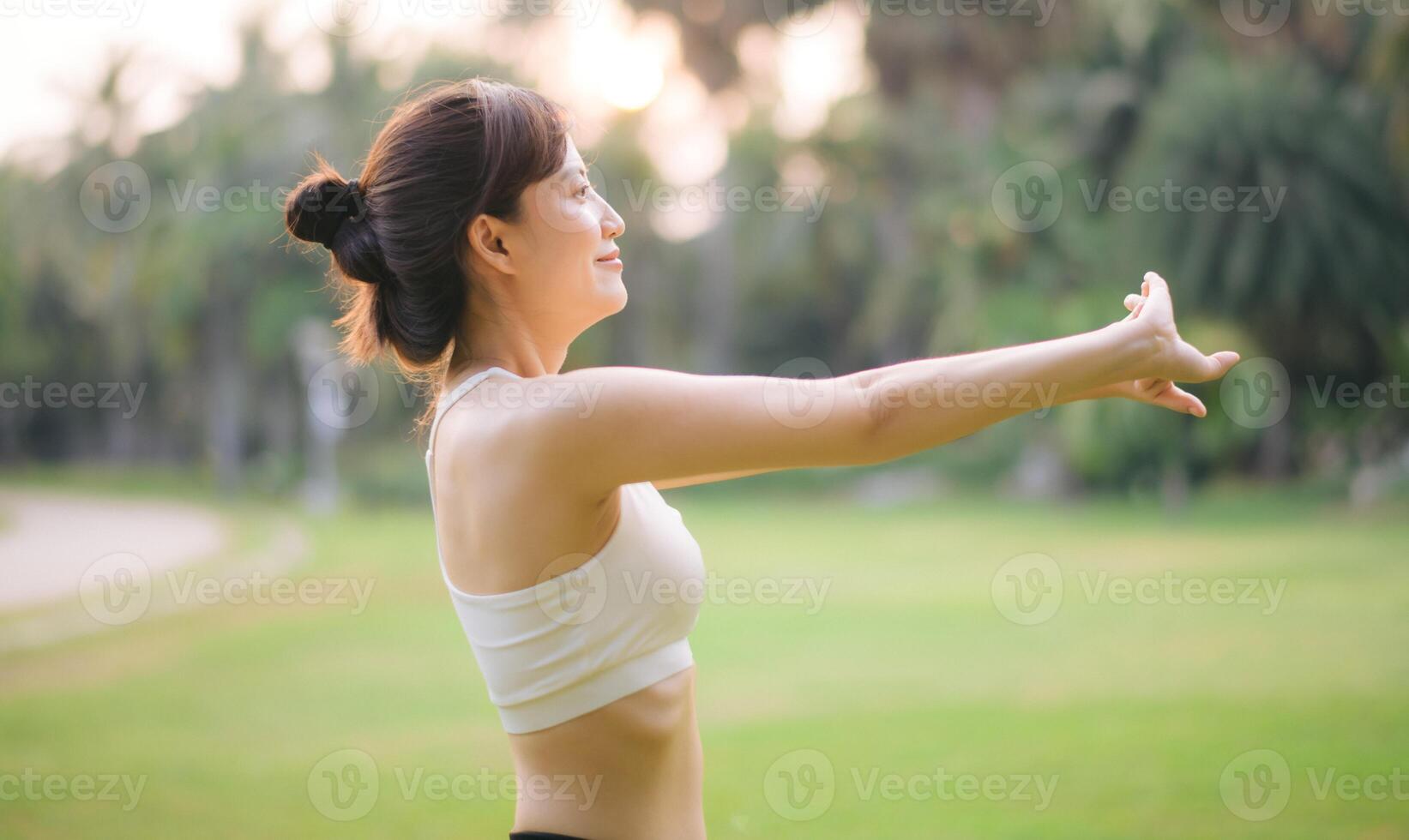 Sportswoman. Fit young Asian woman with sportswear stretching muscle in park before running and enjoying healthy outdoor. Fitness runner girl in public park. Wellness being concept photo