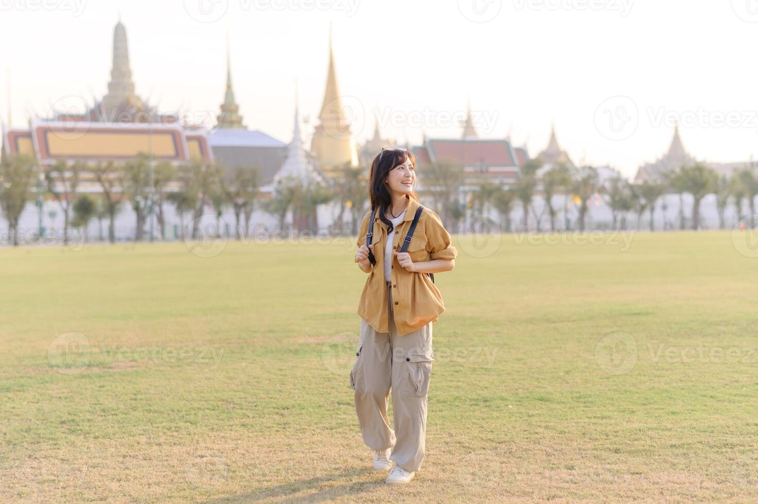 A Traveler Asian woman in her 30s exploring Wat Pra Kaew. From stunning architecture to friendly locals, she cherishes every moment, capturing it all in her heart and camera for years to come. photo