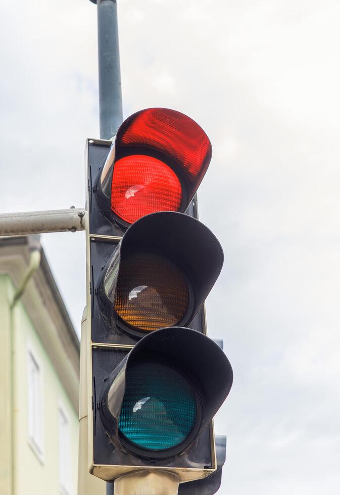 Traffic light, red signal, urban intersection, transportation safety, city skyline, traffic regulation, public transport, clouds concept photo