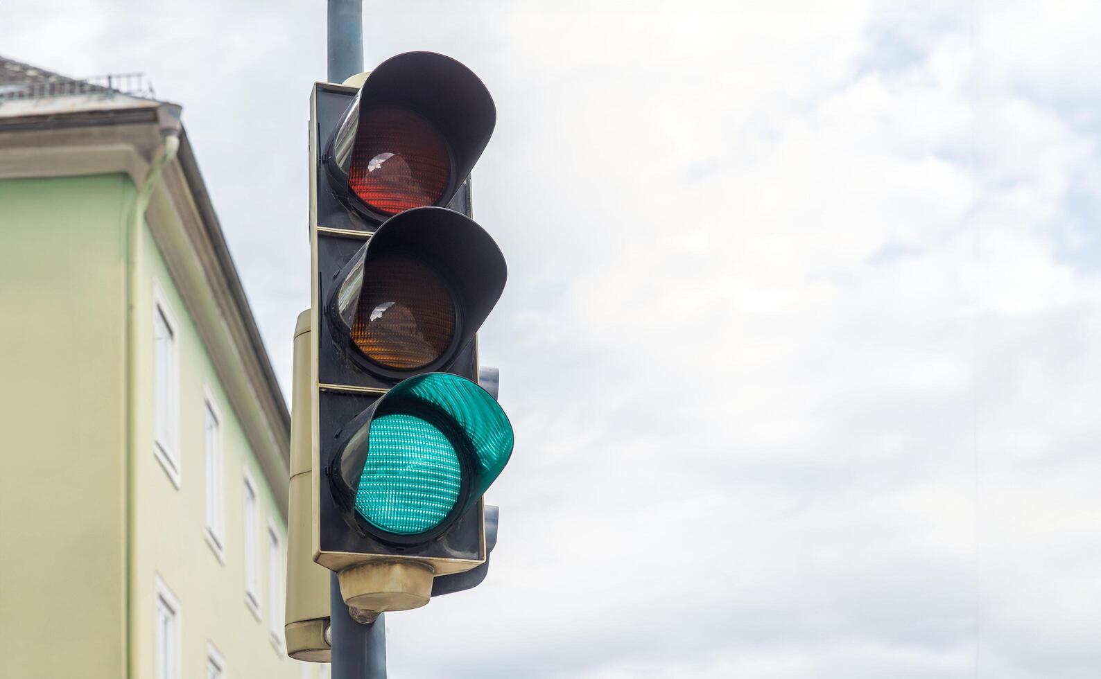 Green traffic light, urban setting, signal forward, clear sky, street safety, transportation, intersection, daytime, city traffic, infrastructure, traffic regulation concept photo