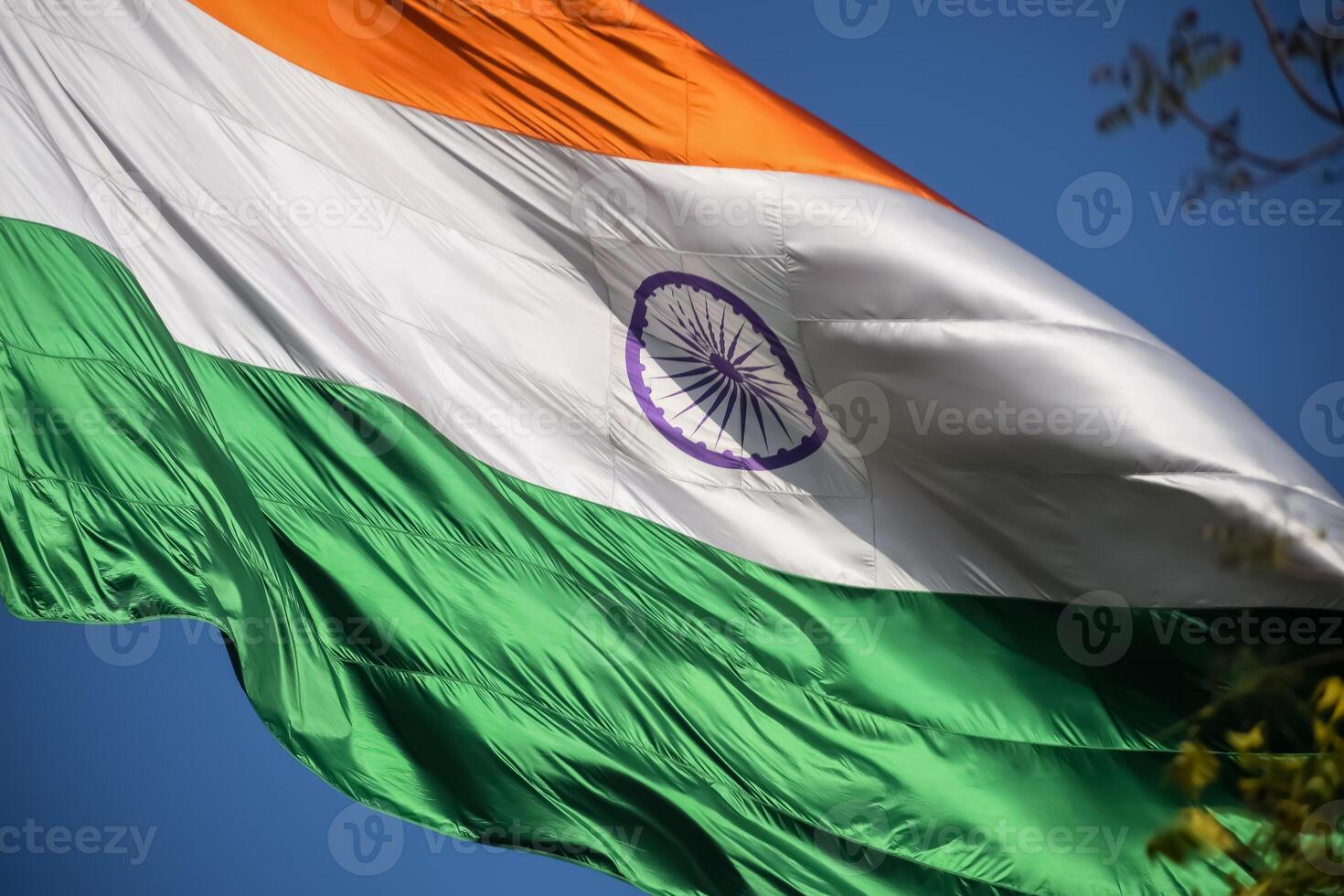 India flag flying high at Connaught Place with pride in blue sky, India flag fluttering, Indian Flag on Independence Day and Republic Day of India, tilt up shot, Waving Indian flag, Har Ghar Tiranga photo