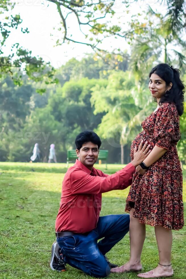 Indian couple posing for Maternity shoot pose for welcoming new born baby in Lodhi Garden in Delhi India, Maternity photo shoot done by parents for welcoming their child, Pre Baby Photo Shoot