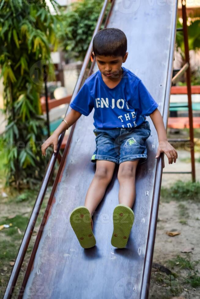 Asian boy doing routine exercise in society park during the morning time. Cute little kid exercise and gym to keep himself fit for life. Child exercise outdoor shoot photo