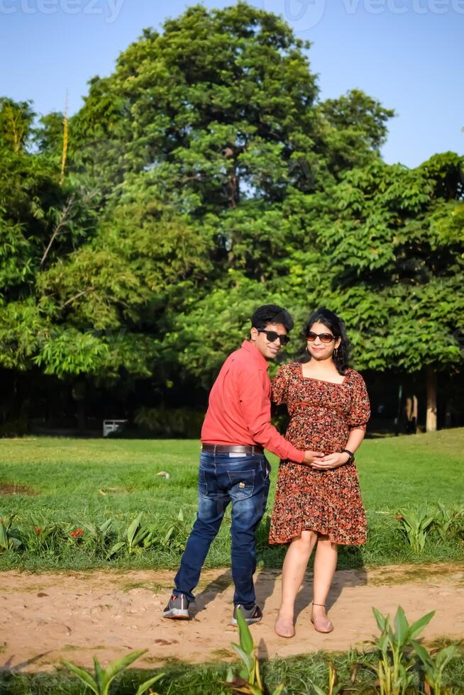Indian couple posing for Maternity shoot pose for welcoming new born baby in Lodhi Garden in Delhi India, Maternity photo shoot done by parents for welcoming their child, Pre Baby Photo Shoot