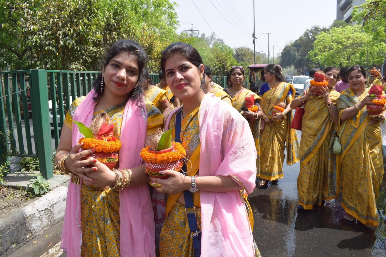 New Delhi, India July 25 2024 - Women with Kalash on head during Jagannath Temple Mangal Kalash Yatra, Indian Hindu devotees carry earthen pots containing sacred water with a coconut on top photo