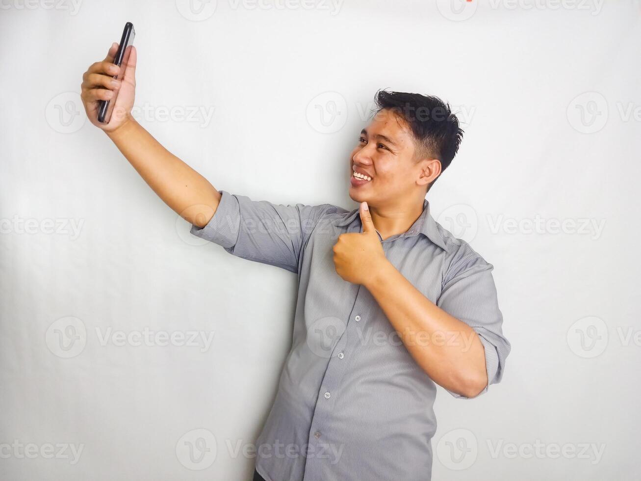 Young Asian man showing hallo and happy when doing call. wearing grey shirt isolated on white background photo