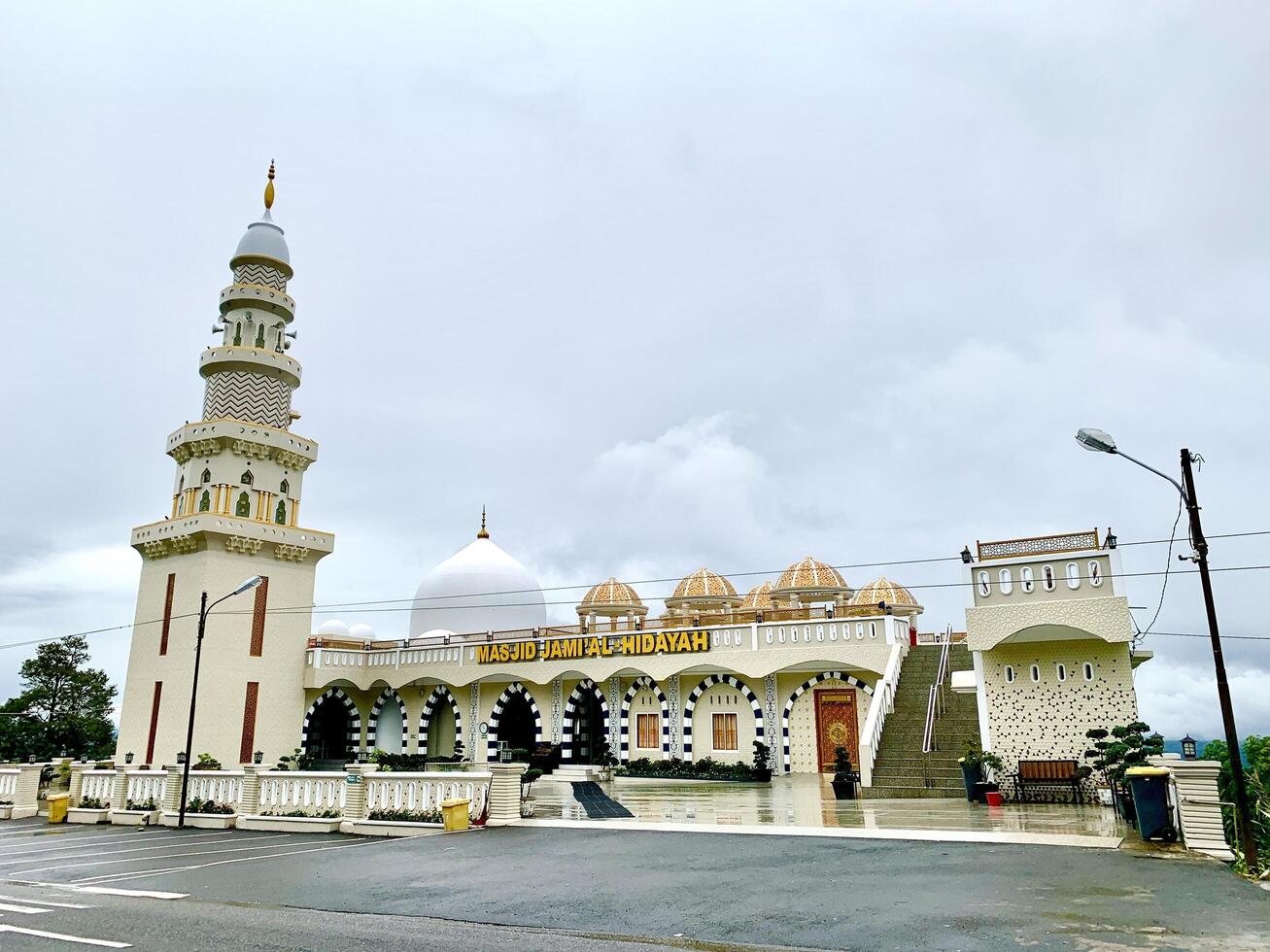 The mosque is white with a large minaret on top. photo