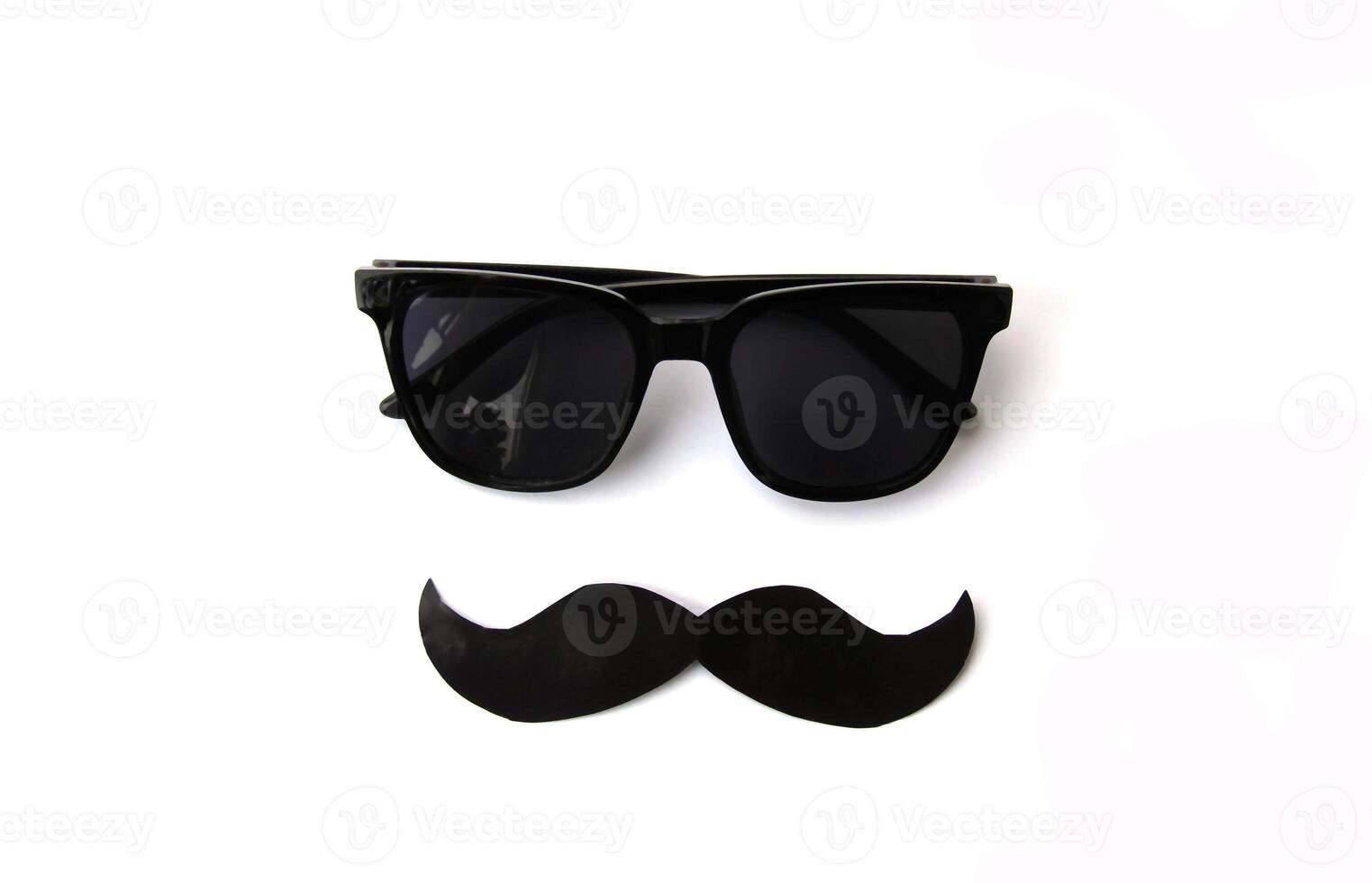 Minimalistic image of black sunglasses and a mustache cut out on a white background. Perfect for use in gaming content, fashion accessories marketing, Movember. Raising awareness about men's health photo