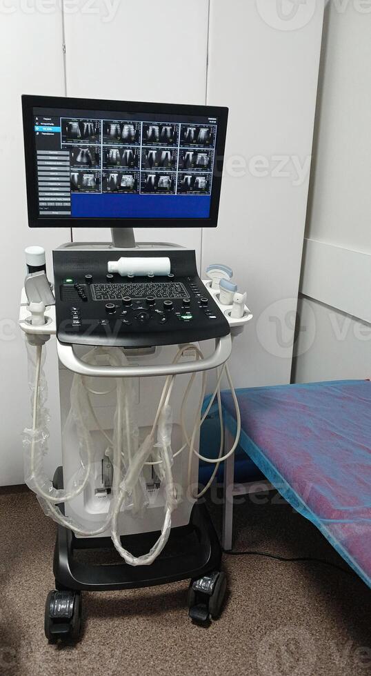 Vertical image of Ultrasound equipment in medical examination room showing monitor with scan, control console and transducers. The setup is prepared for diagnostic tests in a healthcare setting. photo