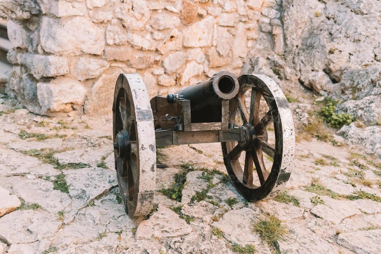 Cannon on a carriage located on a white stone pedestal near the arsenal building in Mirow Castle. Sites of Poland. Architecture of World Tourism. photo