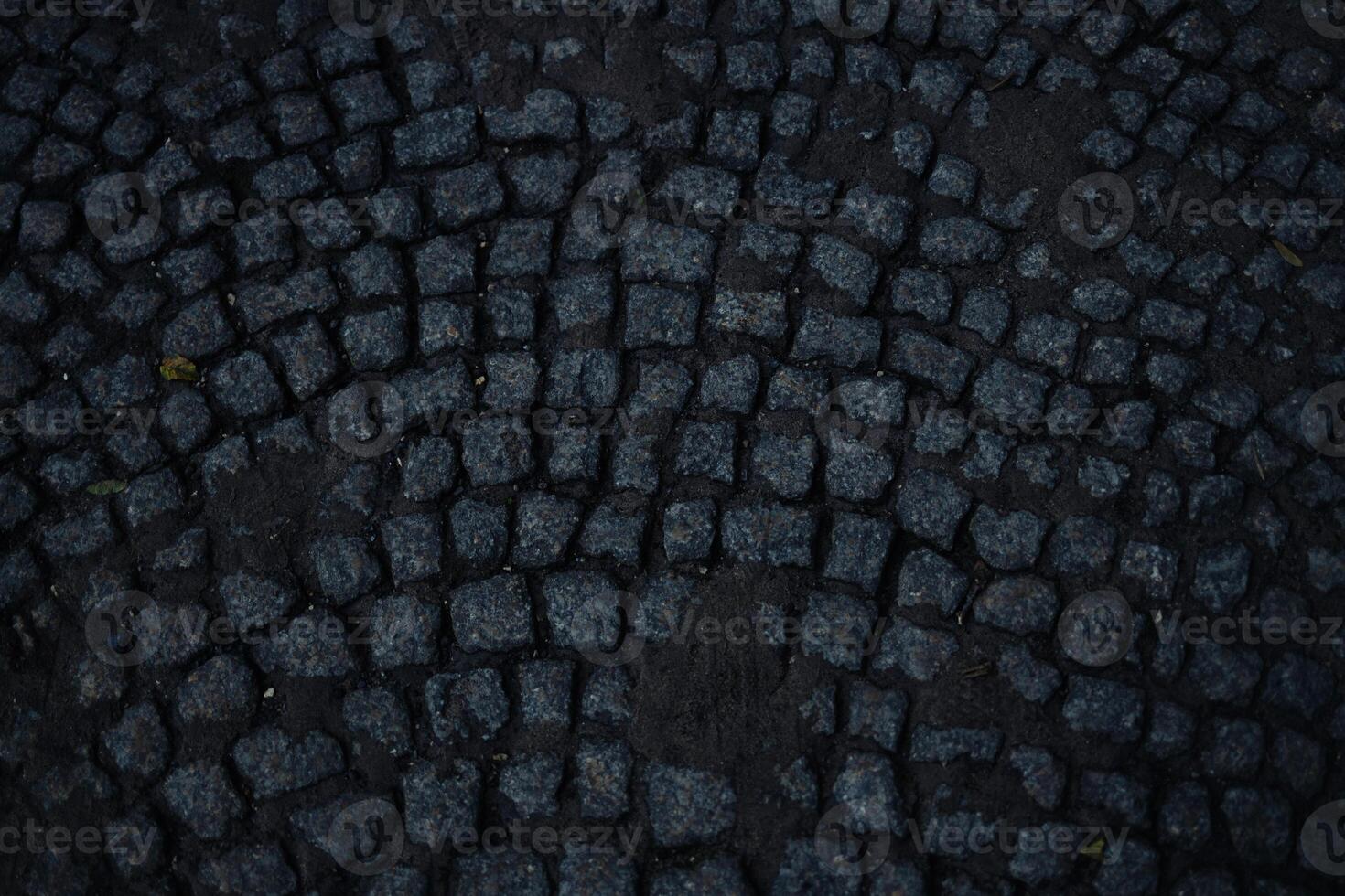 Square pavement paved with gray cobblestones rectangles texture. Cobble stone walkway photo