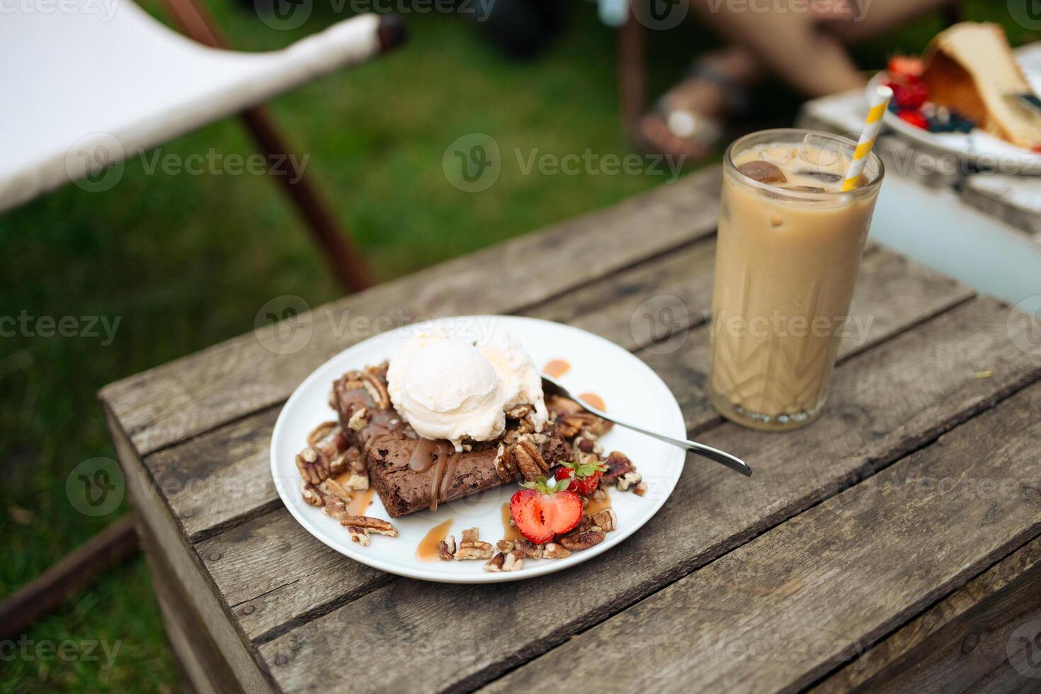 Basic homemade brownie or chocolate cake. Scoop of ice cream on a fresh stack of fresh brownies. Cold brew latte with milk and ice. photo