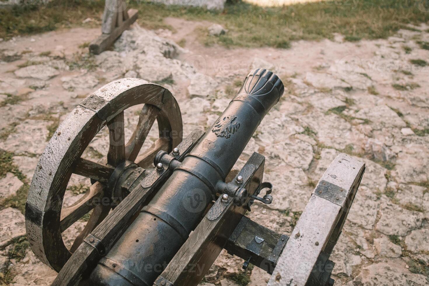 Cannon on a carriage located on a white stone pedestal near the arsenal building in Mirow Castle. Sites of Poland. Architecture of World Tourism. photo