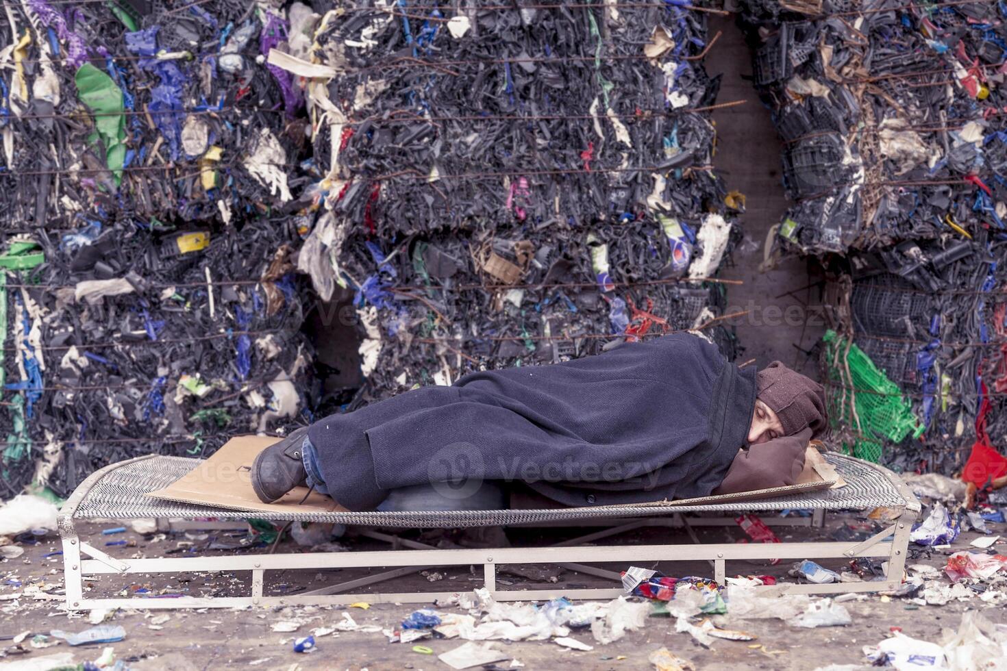 homeless man sleeps in the waste on a wire mesh of bed photo