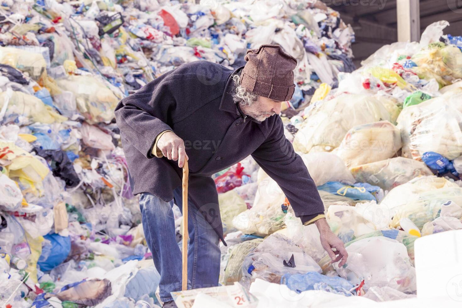 homeless man digs in the garbage photo