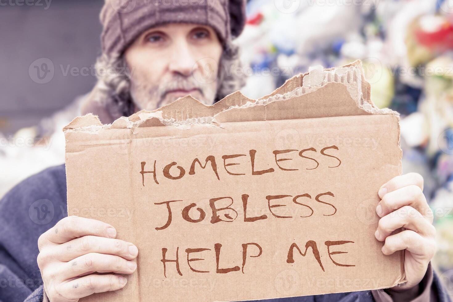 homeless show a help message written on a cardboard photo