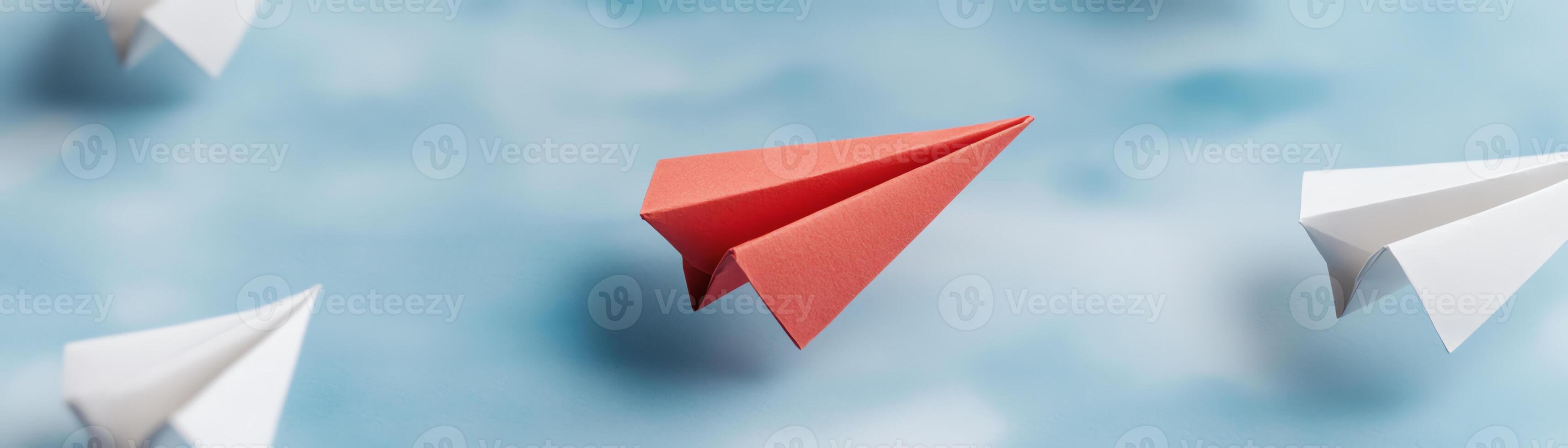 Red paper plane leading white paper planes on a blue background, symbolizing leadership, innovation, and uniqueness. photo