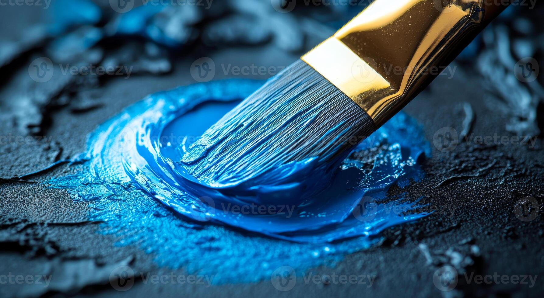 Blue paint on textured black surface. A painter uses a brush to apply bright blue paint onto a textured black canvas, creating an artistic contrast of colors. photo