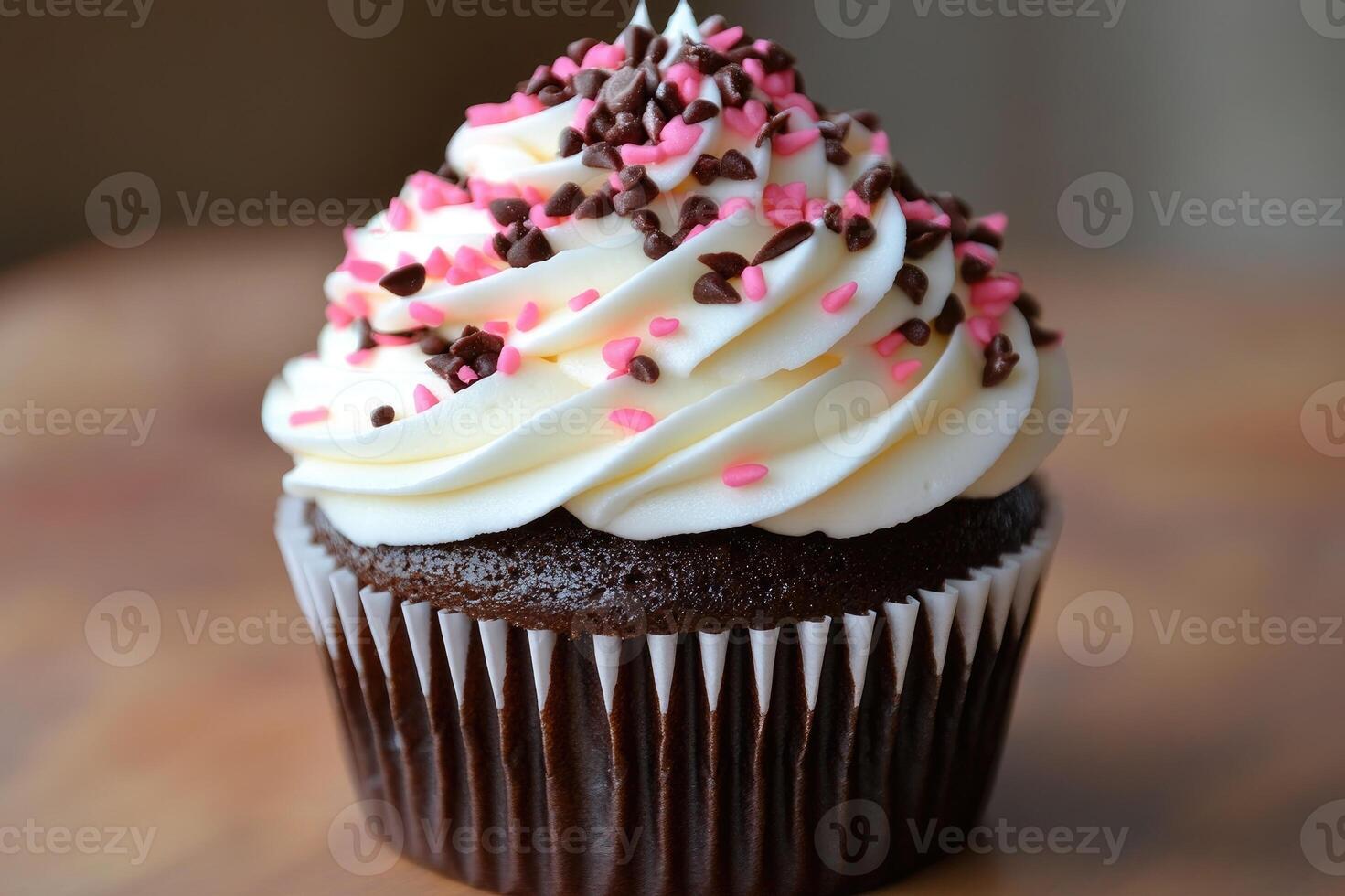 Delicious chocolate cupcake with sprinkles on wooden surface photo