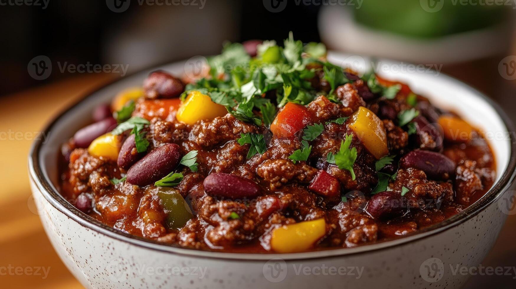 Bowl of chili con carne garnished with cilantro sitting on tabletop photo