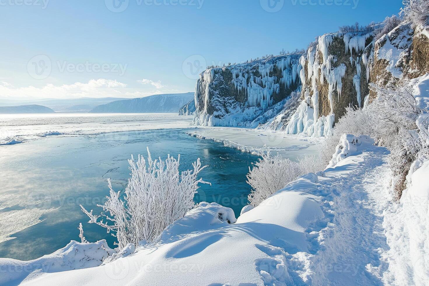 Snowy path winding along frozen lake baikal with icicles photo