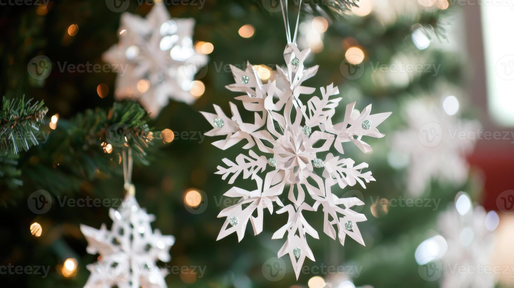 White Paper Snowflake Ornament Hanging on a Christmas Tree photo