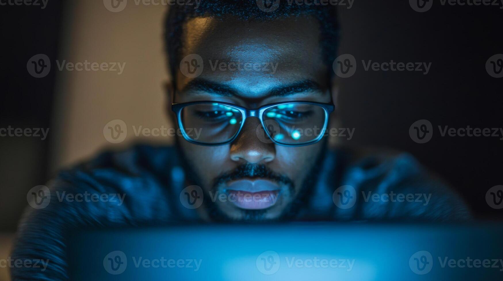 Close-up of a man in glasses looking at a laptop screen photo