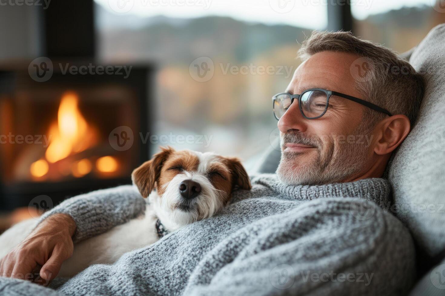 Man relaxing by a cozy fireplace with a sleeping dog photo