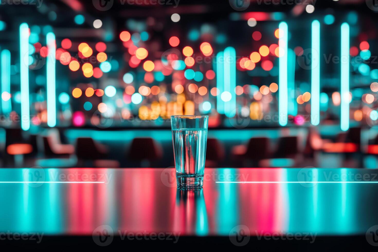 Glass of alcohol on a table in a bar with vibrant neon lighting. Atmospheric nightlife photo