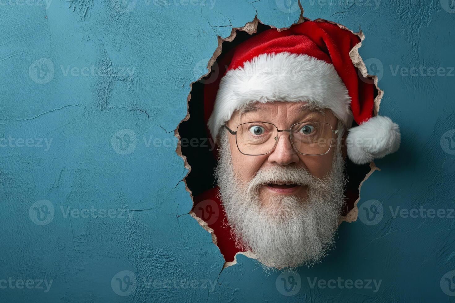 Santa Claus peeking through a hole in a blue background photo